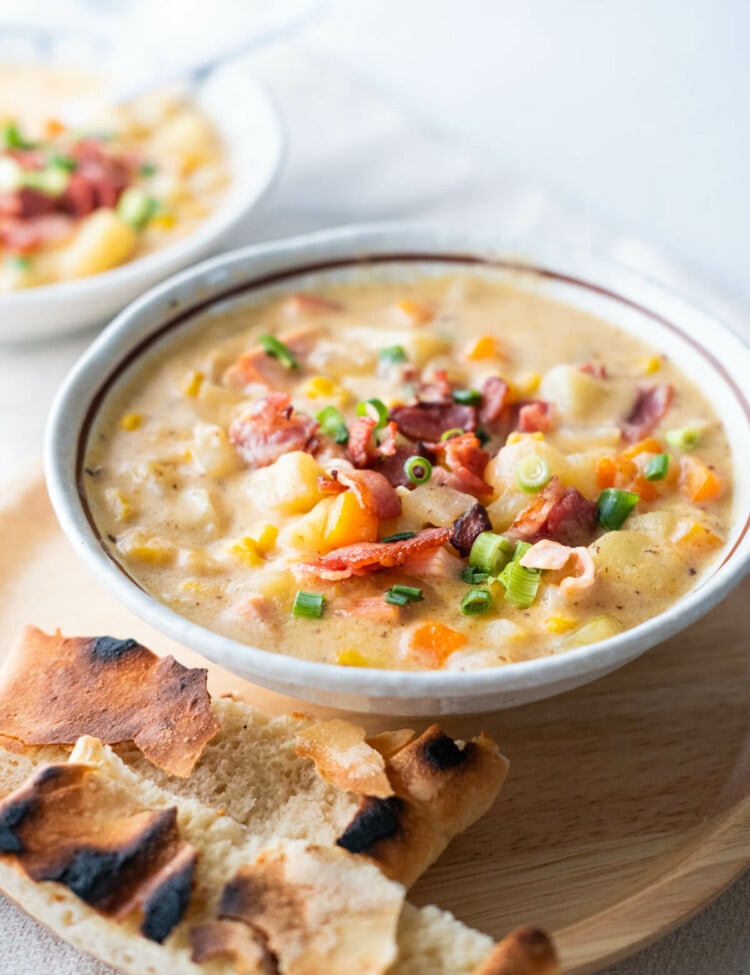 Easy, delicious cheesy ham chowder served in a bowl with pita bread on the side.