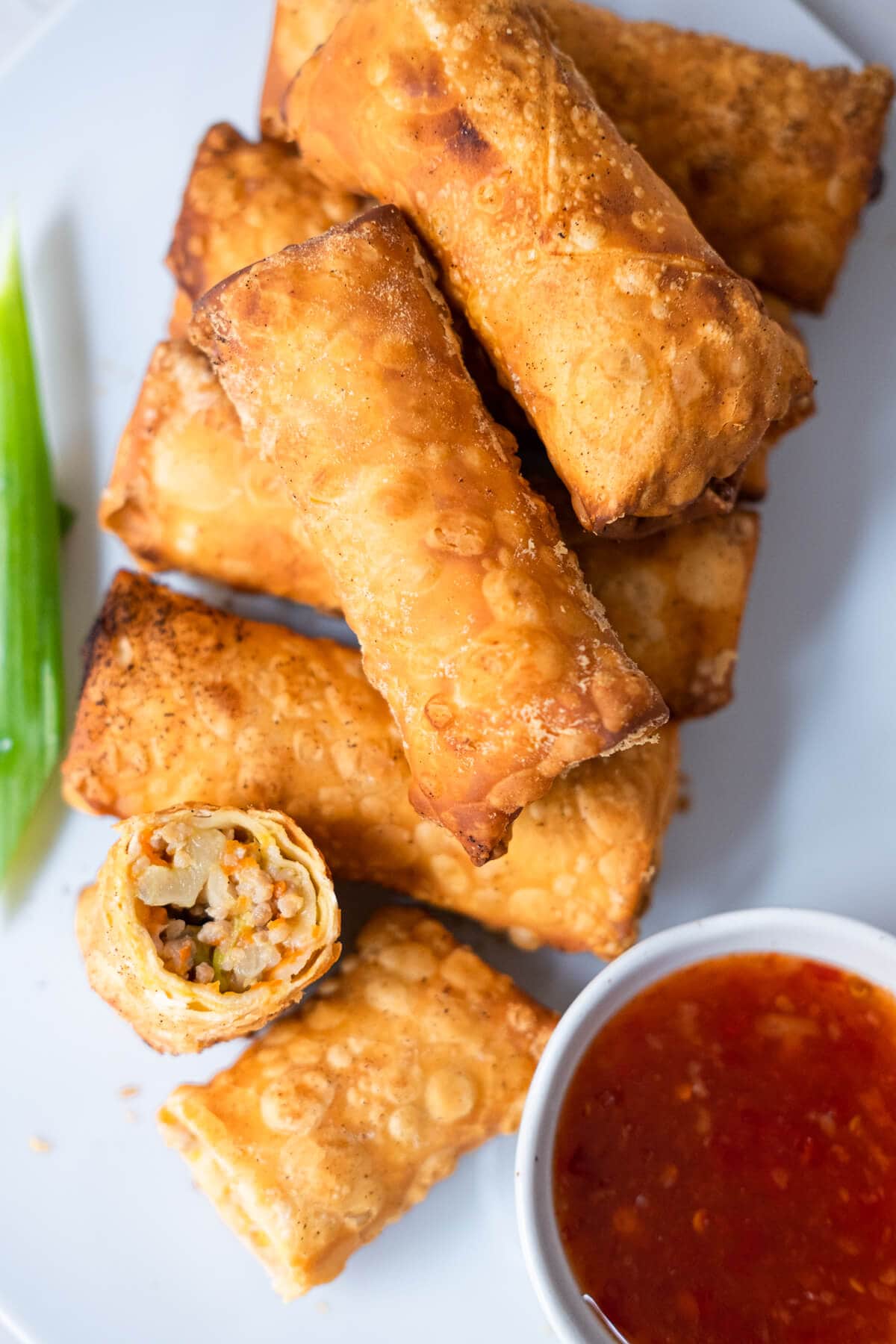 Chicken egg rolls with sweet chili sauce on the side. 