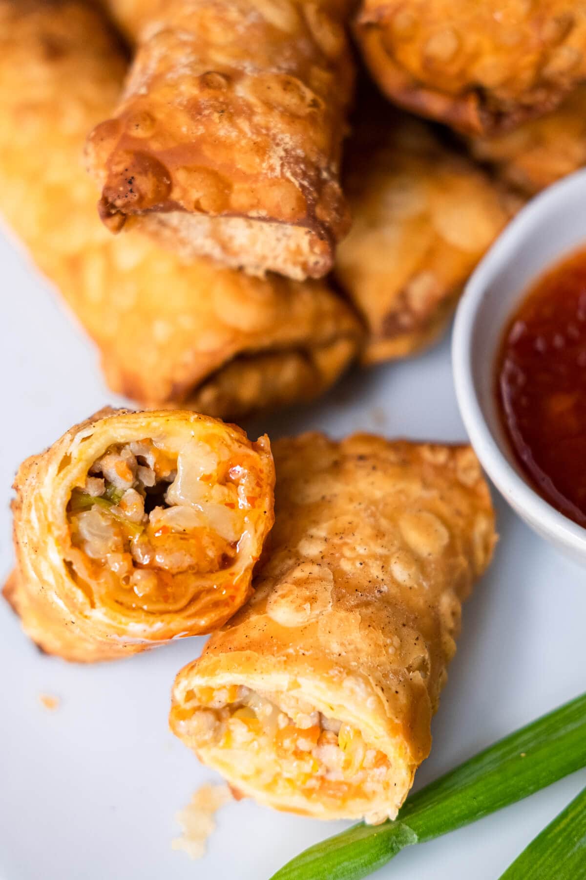 Chicken egg rolls dipped with sweet chili sauce. 