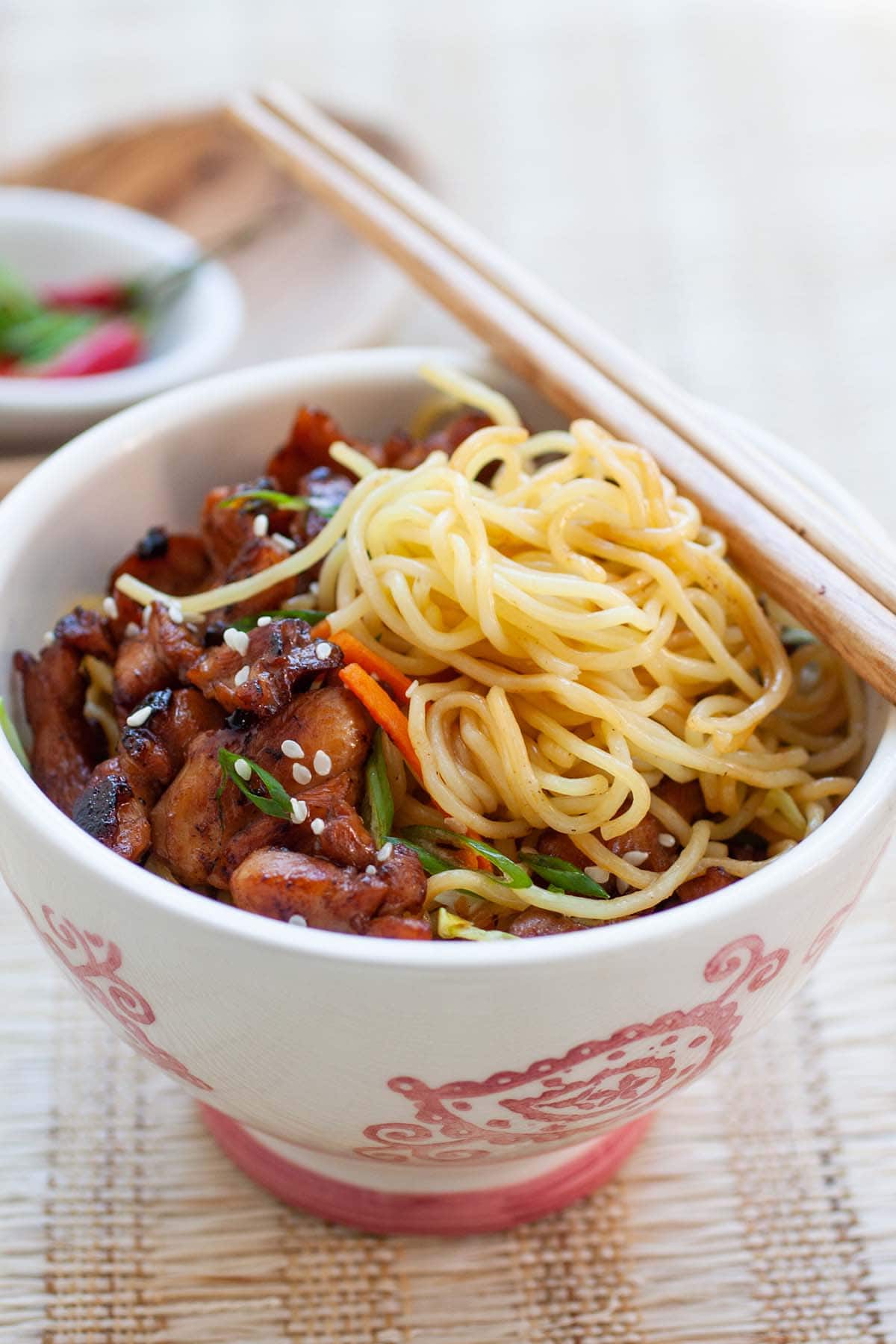 Delicious stir-fried egg noodles with chicken in a bowl, ready to be served.