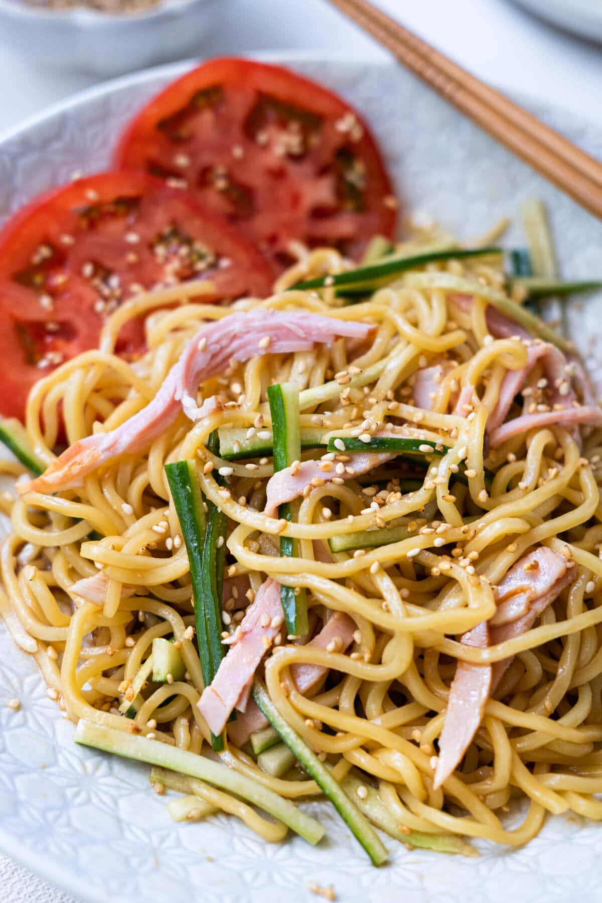 Easy and quick cold sesame noodle with tomato slices, julienne cucumber and ham slices.