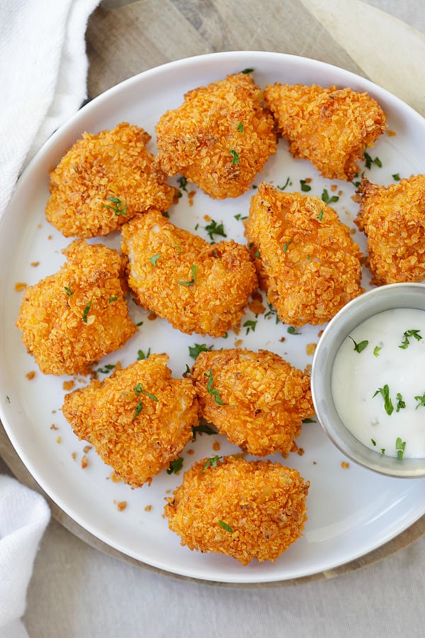 Tortilla Chip-crusted Chicken Bites on a plate with a side of dipping sauce.
