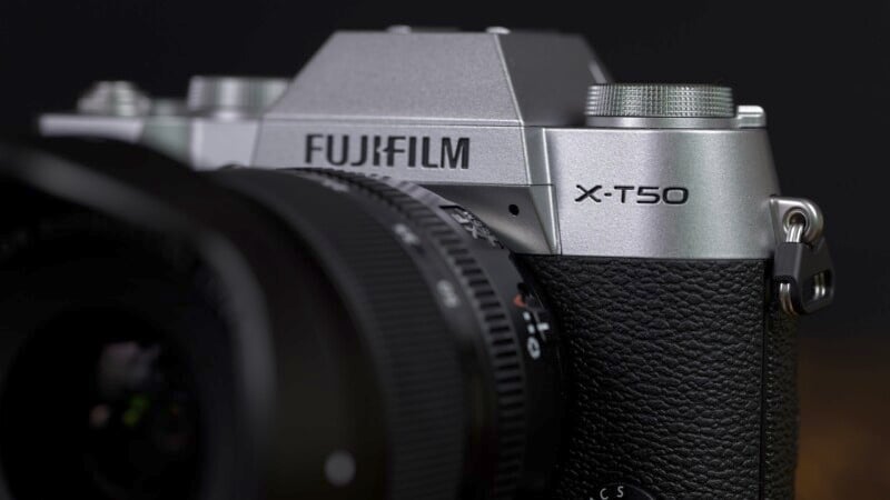 Close-up of a Fujifilm X-T50 camera highlighting the textured grip and detailed branding on a dark background.