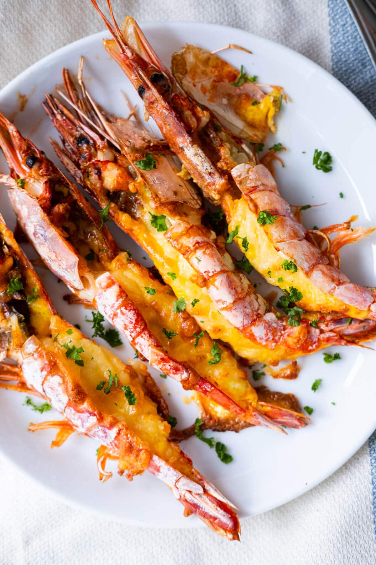 Grilled cheese prawns with chopped parsley on top. 