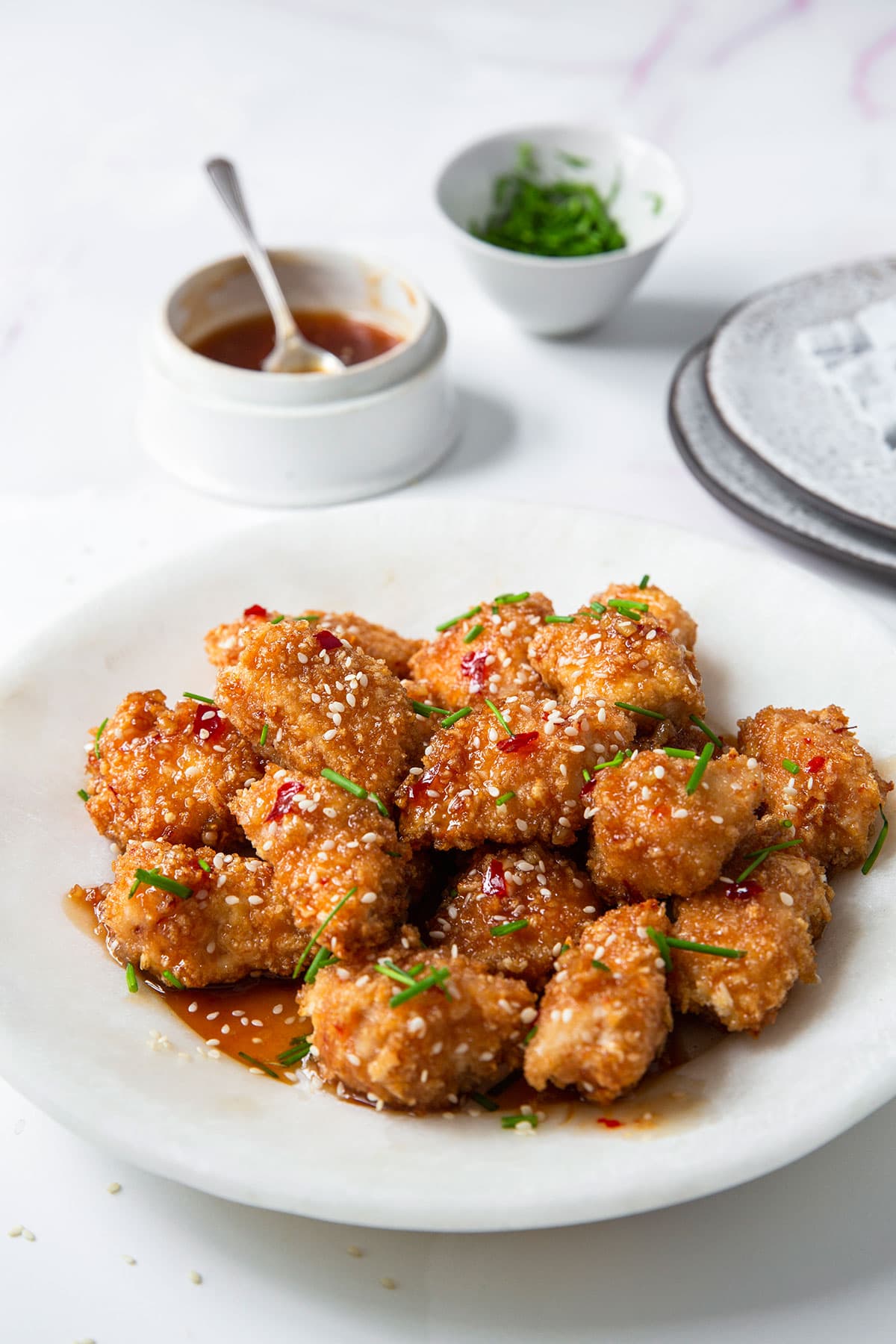 Easy and quick crispy panko-crusted baked chicken nuggets with a sweet and savory honey garlic sauce in a plate.