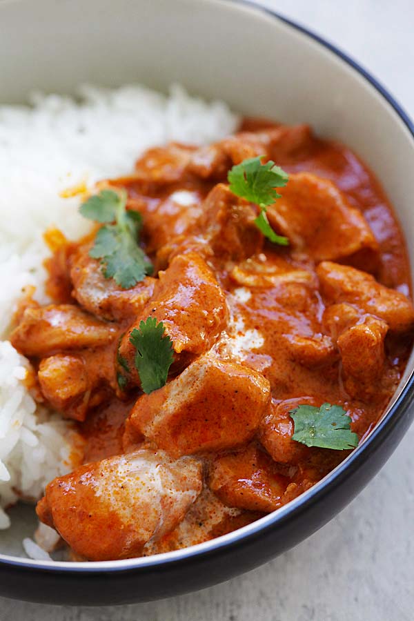 Butter chicken instant pot with butter chicken sauce served with rice on a plate.
