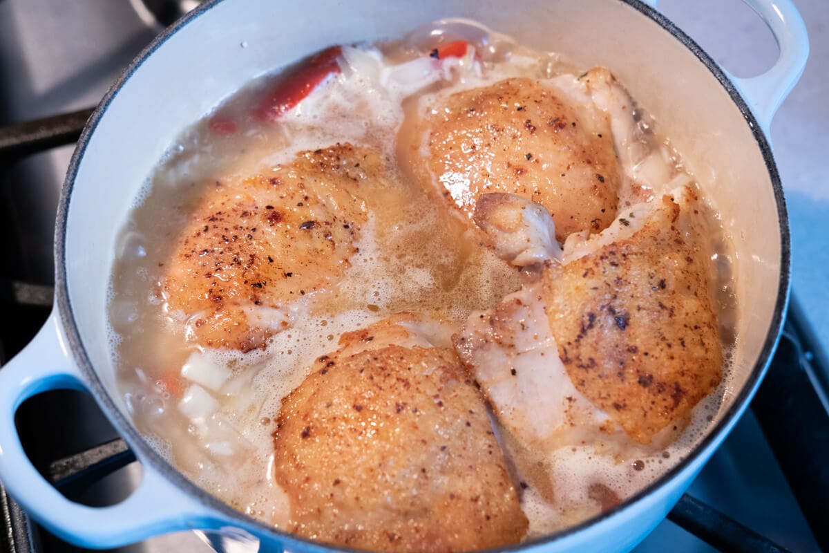 Add seared chicken thighs to the pot and cook for 15 minutes. 