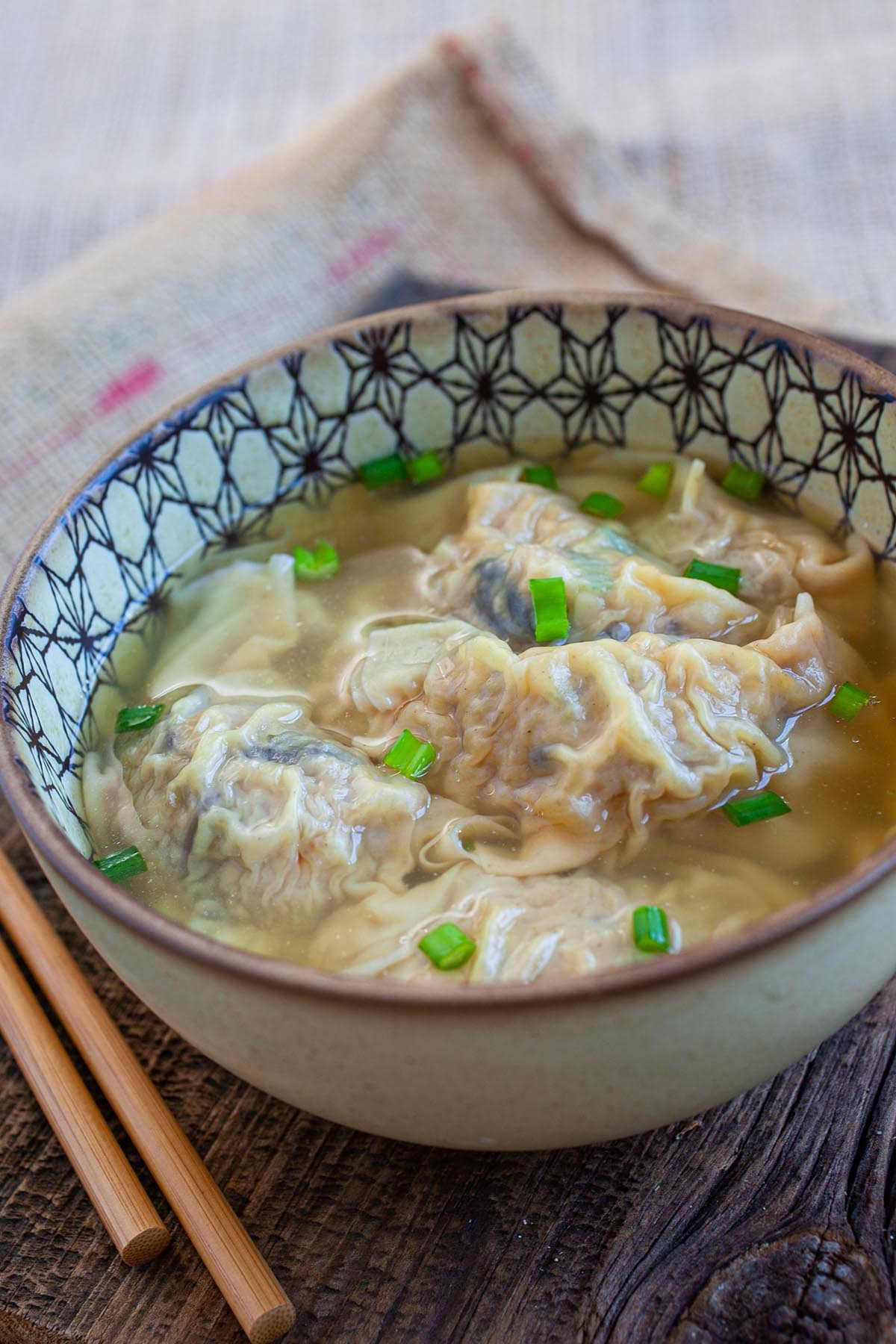 Chinese chicken soup with pork gyoza in a bowl.