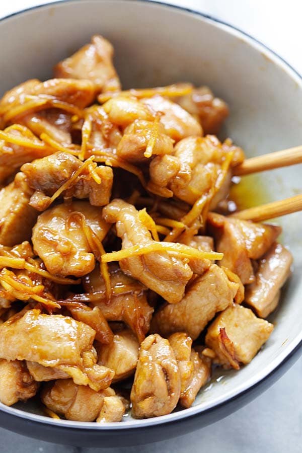 Easy homemade Asian sesame oil chicken with a pair of chopsticks.