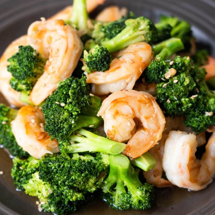 Shrimp and broccoli stir-fry with white sesame seeds sprinkled on top.