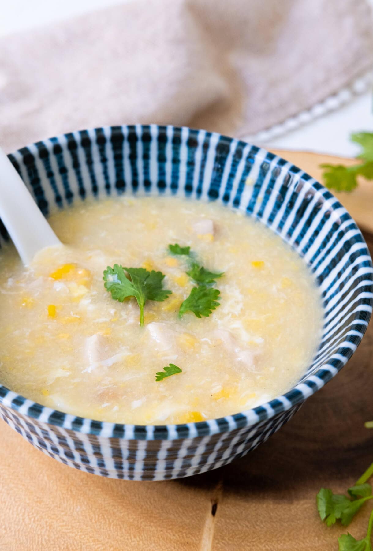 Sweet corn and chicken soup served with cilantro on top.